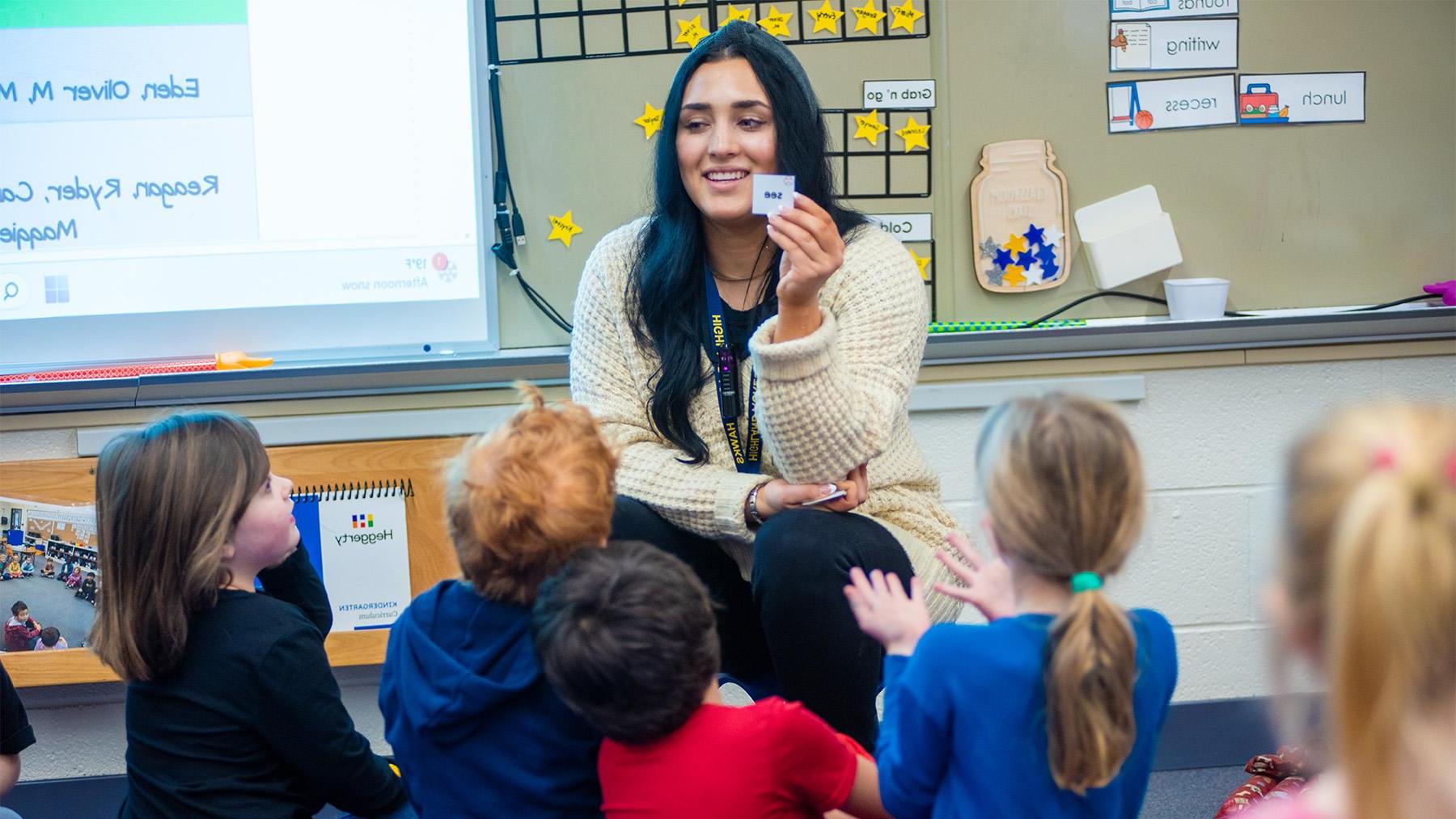 A female teachers teaching reading to a class of kindergartners